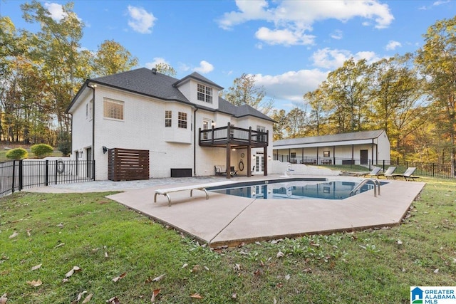 back of property featuring a patio, a balcony, a fenced in pool, and a yard