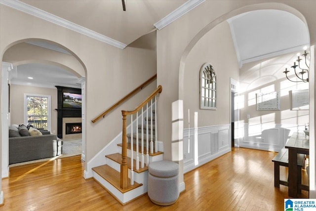 entrance foyer featuring hardwood / wood-style floors, a large fireplace, and ornamental molding