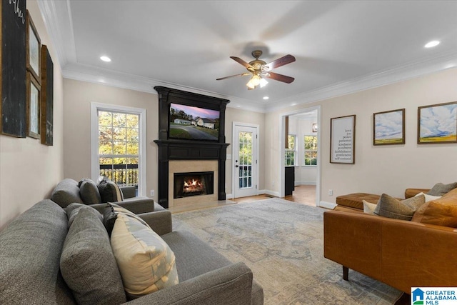 living room with ornamental molding, a large fireplace, and ceiling fan