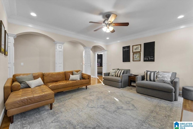 living room with hardwood / wood-style flooring, ceiling fan, ornate columns, and ornamental molding