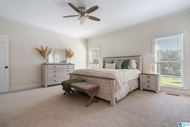 carpeted bedroom featuring ceiling fan, multiple windows, and ornamental molding