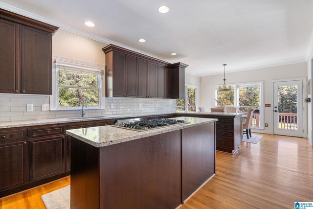 401 El Camino Real, Chelsea, AL 35043 - kitchen with a sink, stainless steel gas stovetop, ornamental molding, decorative backsplash, and a kitchen island
