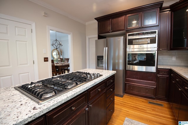 401 El Camino Real, Chelsea, AL 35043 - kitchen with appliances with stainless steel finishes, light wood finished floors, ornamental molding, light stone countertops, and glass insert cabinets