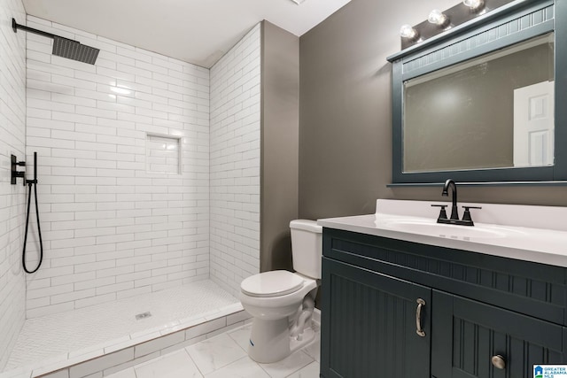 bathroom featuring toilet, vanity, and tiled shower