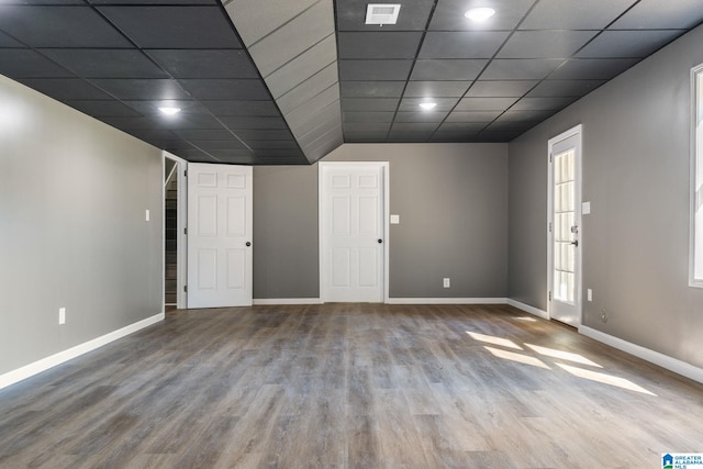 unfurnished room with wood-type flooring and a drop ceiling