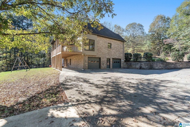 view of side of home featuring a garage and a lawn