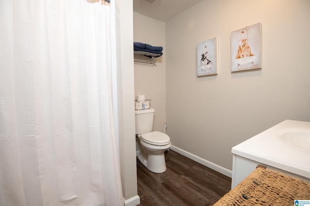 bathroom featuring toilet, vanity, and hardwood / wood-style floors