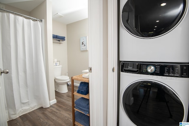 washroom with stacked washing maching and dryer and hardwood / wood-style floors