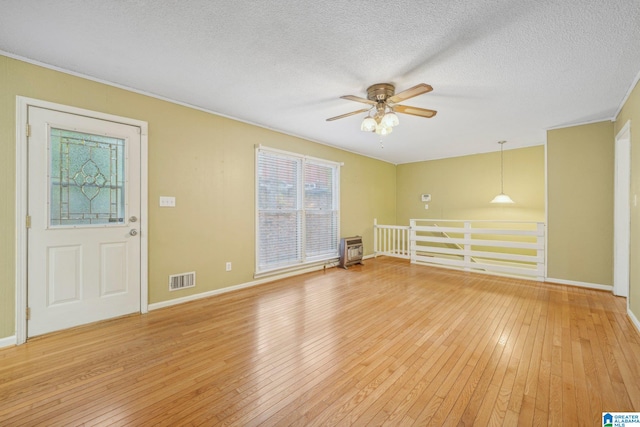 empty room with hardwood / wood-style floors, ceiling fan, and a textured ceiling