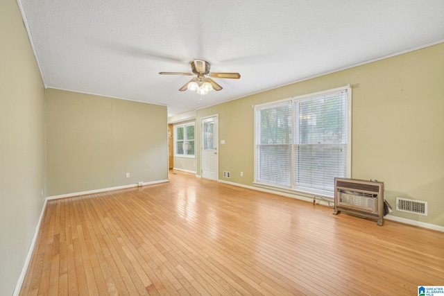 spare room with light hardwood / wood-style floors, ceiling fan, and a textured ceiling