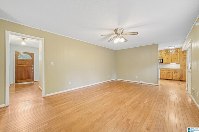 unfurnished living room featuring ornamental molding, light wood-type flooring, and ceiling fan