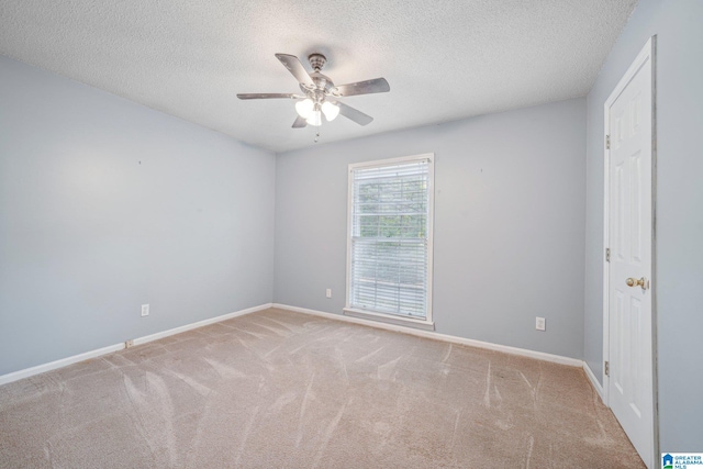 carpeted spare room featuring a textured ceiling and ceiling fan