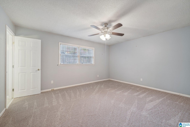 unfurnished room with ceiling fan, a textured ceiling, and carpet flooring