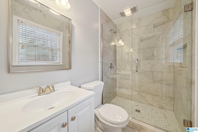 bathroom featuring toilet, vanity, and an enclosed shower