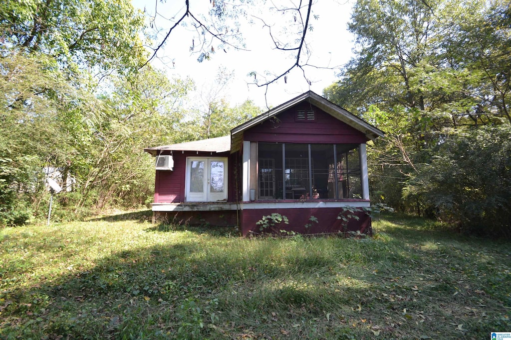 back of property featuring a lawn and a sunroom