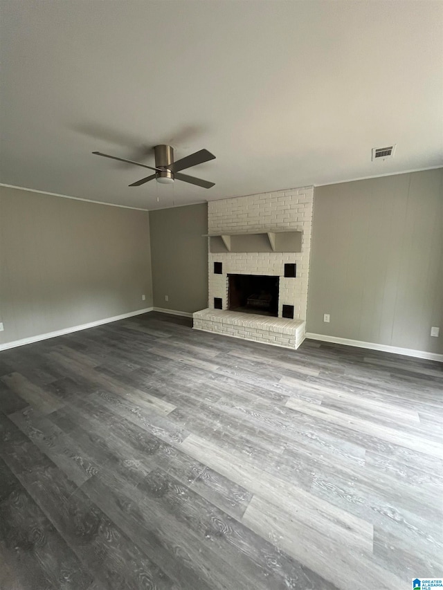 unfurnished living room with ceiling fan, hardwood / wood-style floors, and a brick fireplace