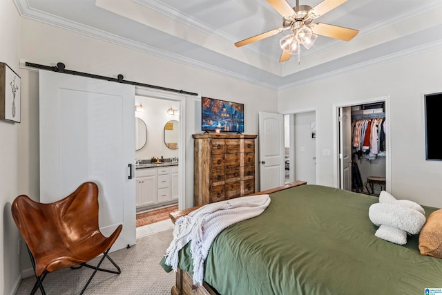 carpeted bedroom featuring crown molding, a barn door, ceiling fan, and ensuite bathroom