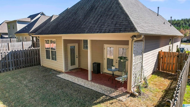 back of house featuring a yard, a patio, and french doors