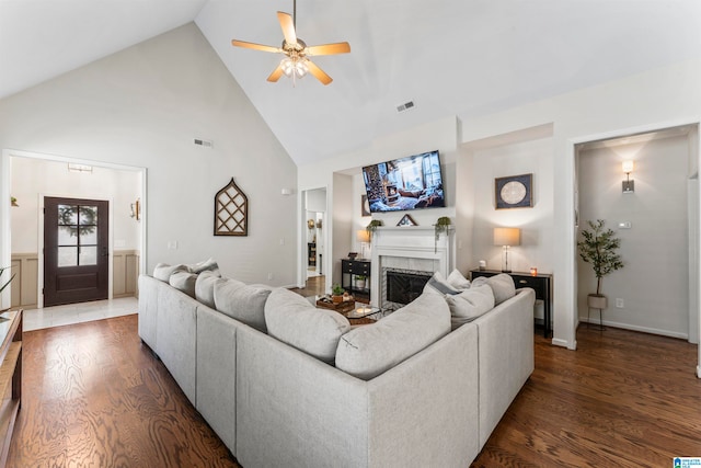 living room with dark hardwood / wood-style flooring, high vaulted ceiling, and ceiling fan