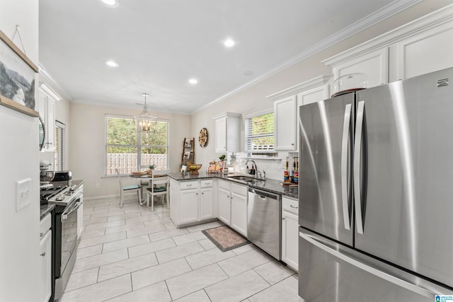 kitchen featuring stainless steel appliances, plenty of natural light, white cabinets, and sink