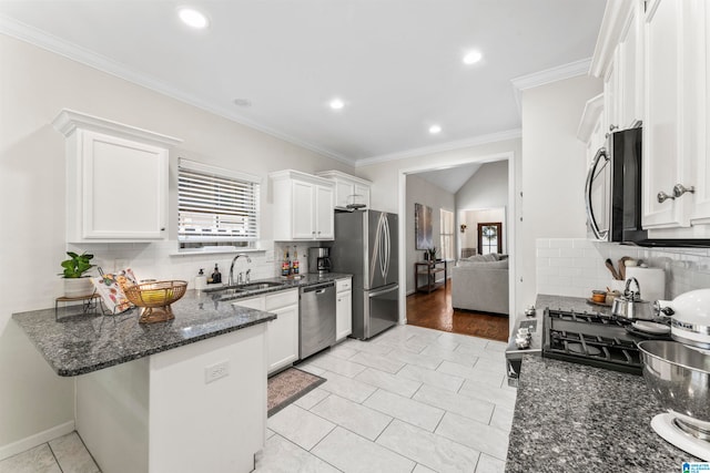 kitchen featuring dark stone countertops, white cabinetry, appliances with stainless steel finishes, and ornamental molding