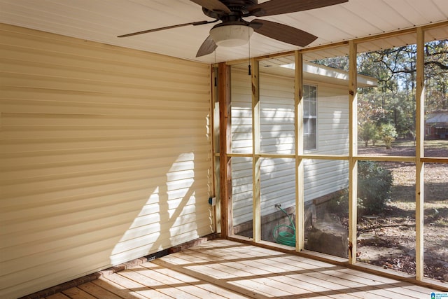 unfurnished sunroom featuring ceiling fan