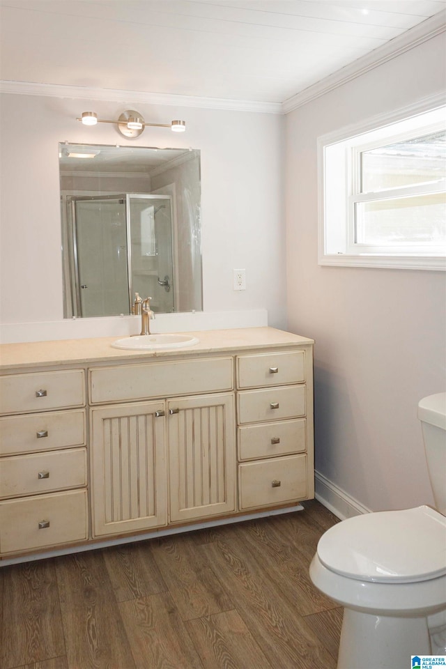 bathroom featuring wood-type flooring, toilet, ornamental molding, vanity, and walk in shower