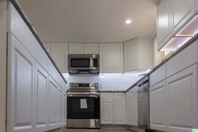 kitchen featuring white cabinets, decorative backsplash, light stone counters, and stainless steel appliances