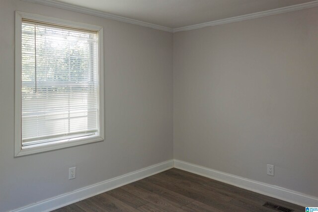 empty room with ornamental molding and dark wood-type flooring