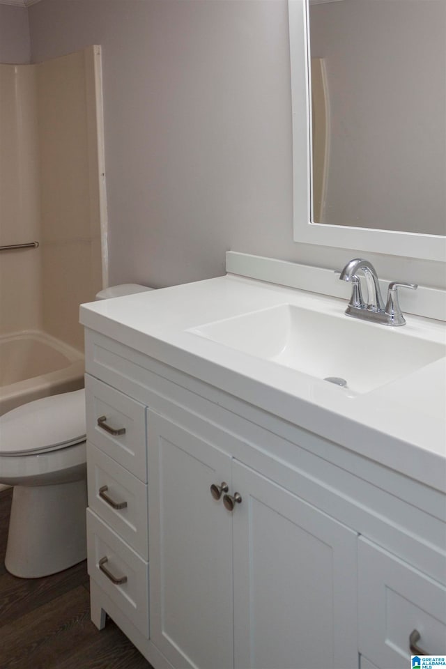 full bathroom with toilet, washtub / shower combination, vanity, and wood-type flooring