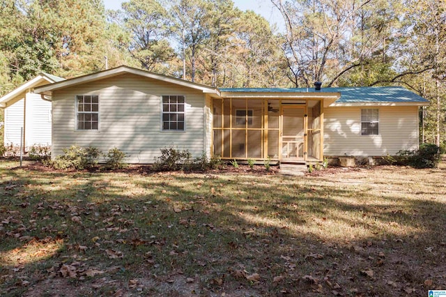 rear view of house with a sunroom and a lawn