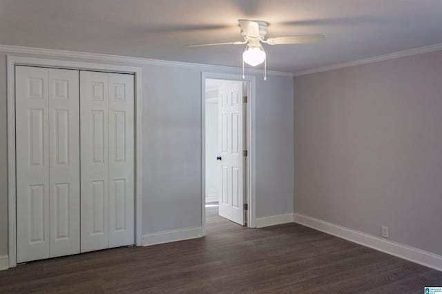 unfurnished bedroom featuring dark wood-type flooring, ceiling fan, a closet, and crown molding