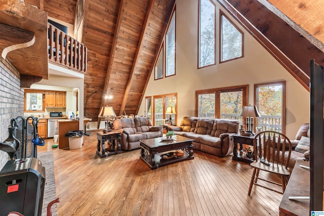 living room with beam ceiling, light wood-type flooring, high vaulted ceiling, and wood ceiling