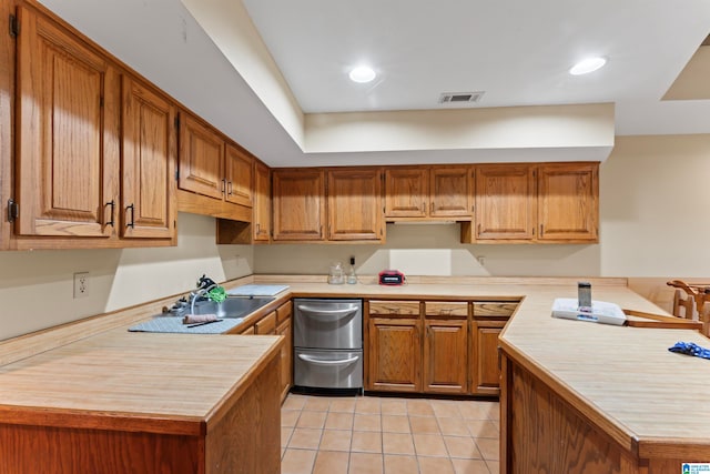 kitchen featuring stainless steel dishwasher, light tile patterned floors, kitchen peninsula, and sink