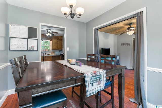 dining room with ceiling fan with notable chandelier, hardwood / wood-style flooring, and sink