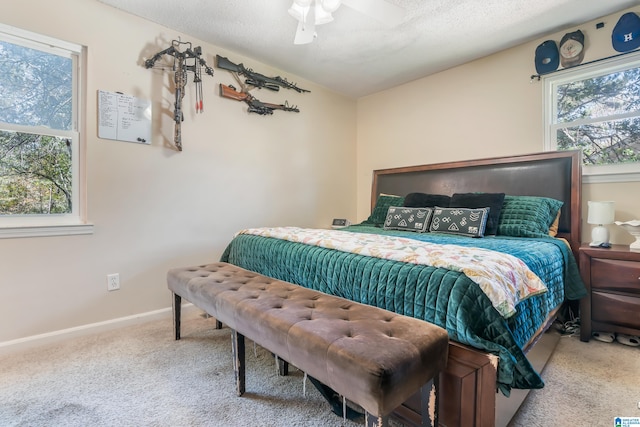 carpeted bedroom with multiple windows, a textured ceiling, and ceiling fan