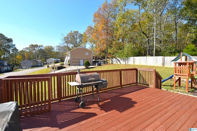 wooden deck with a playground, area for grilling, and a lawn