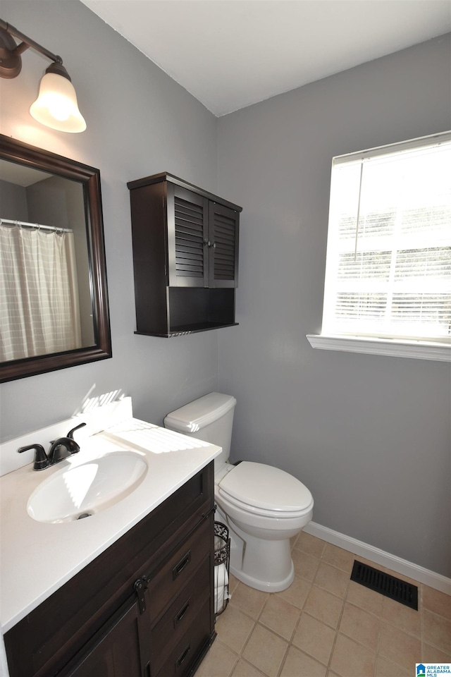 bathroom featuring tile patterned floors, vanity, and toilet