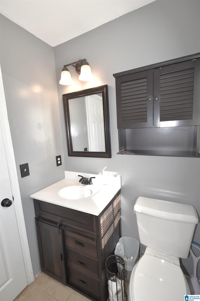 bathroom with tile patterned flooring, vanity, and toilet