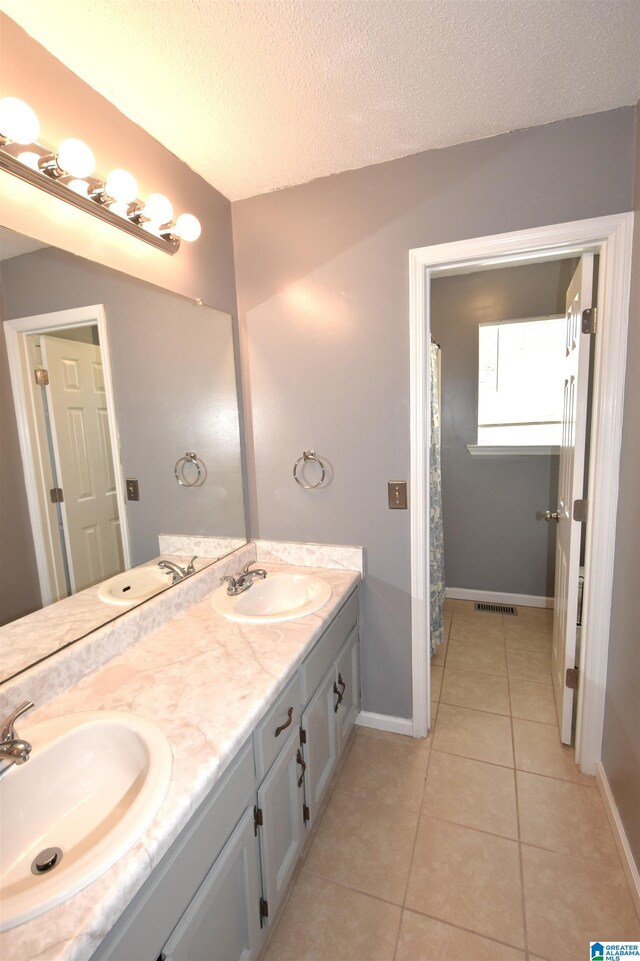 bathroom featuring tile patterned floors, vanity, and a textured ceiling