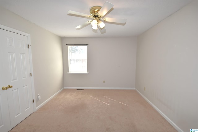 carpeted spare room with ceiling fan