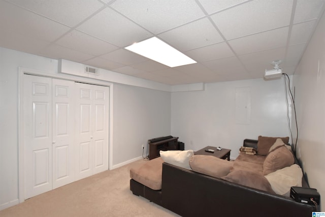 living room featuring electric panel, a drop ceiling, and carpet