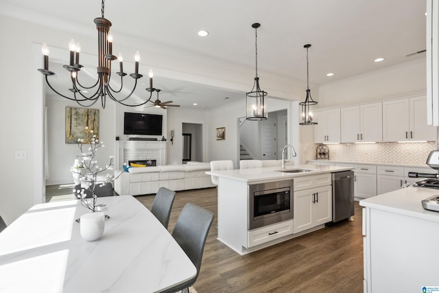 kitchen featuring a center island with sink, sink, white cabinetry, and appliances with stainless steel finishes