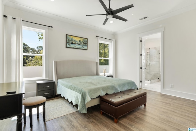 bedroom with hardwood / wood-style flooring, ceiling fan, connected bathroom, and crown molding