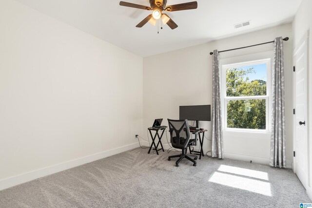 carpeted office space featuring ceiling fan