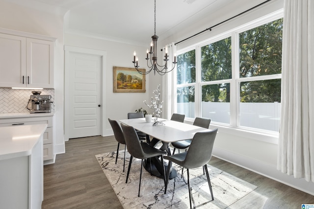 dining room featuring dark hardwood / wood-style flooring, crown molding, and an inviting chandelier