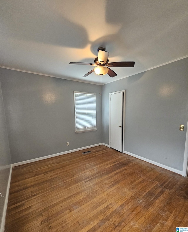 spare room featuring crown molding, hardwood / wood-style floors, and ceiling fan