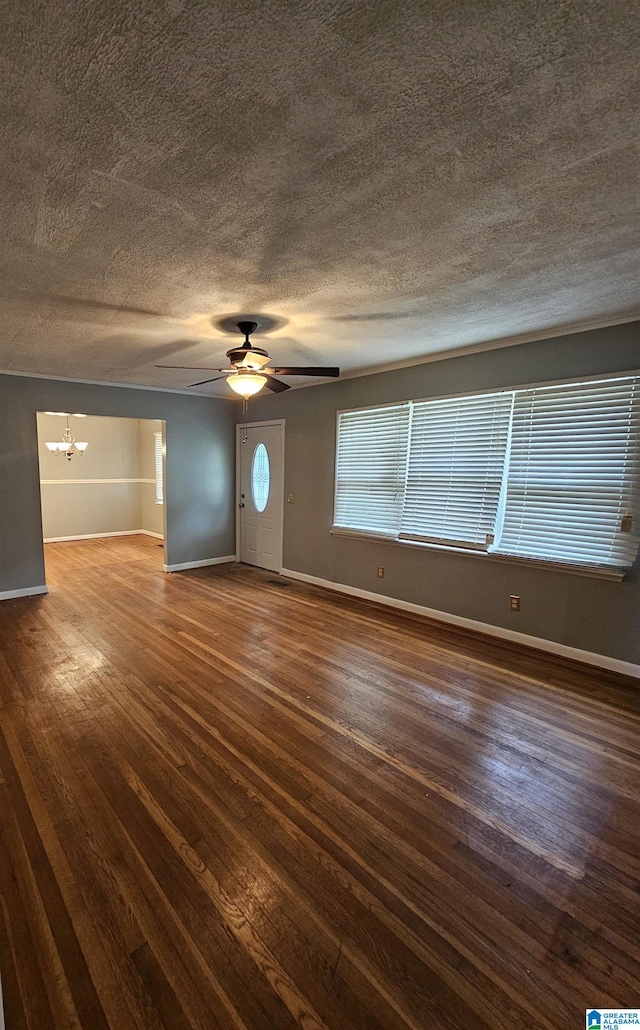 interior space featuring dark hardwood / wood-style flooring, ceiling fan with notable chandelier, and a textured ceiling