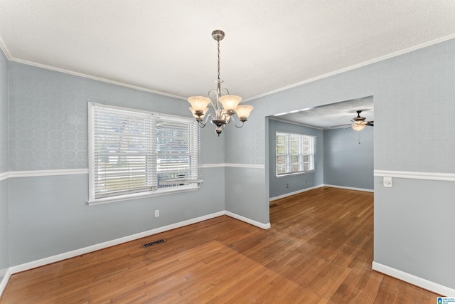 unfurnished dining area with hardwood / wood-style floors, ceiling fan with notable chandelier, and ornamental molding