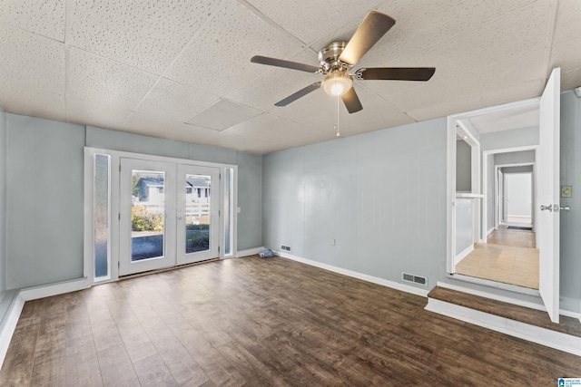 empty room featuring ceiling fan, wood-type flooring, and french doors